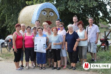 A vendégváró szalmabábu és a bábuállító csapat (Lakatos János felvétele)