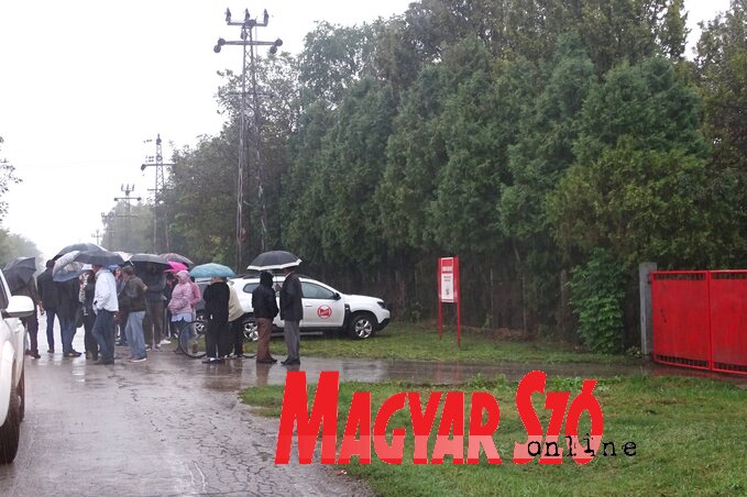 A sok panaszra okot adó sertéstelep bejárata előtt szakadó esőben tüntettek csütörtökön a közelben lakók (Góbor Béla felvétele)