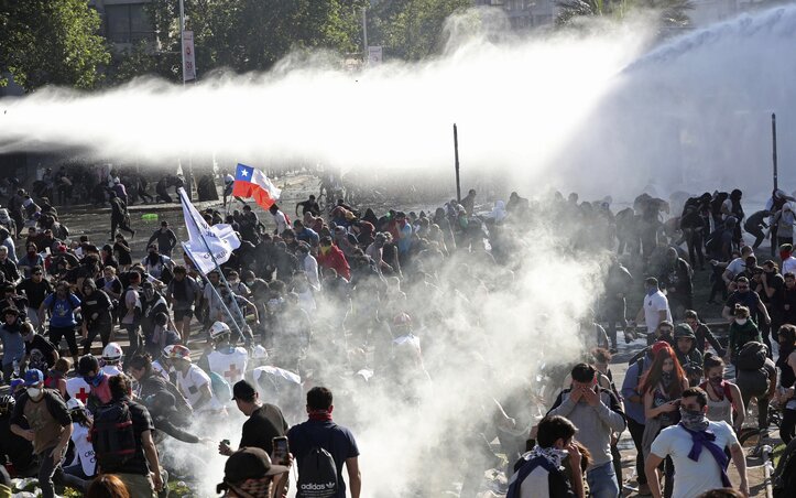 A rendőrség vízágyúkkal és könnygázzal igyekezett lehűteni az indulatokat Santiago de Chilében (Fotó: AP via Beta)