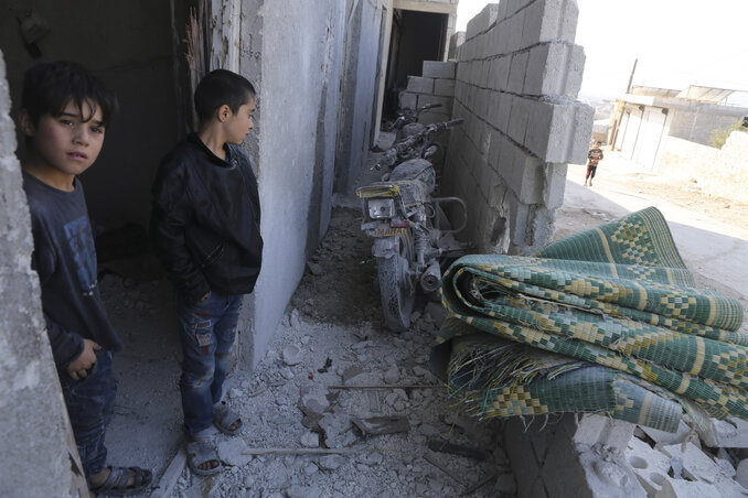 Két fiú ácsorog romokban álló otthonuk előtt az Idlíb-körzetbeli Barisában, közel ahhoz a helyhez, ahol az amerikai kommandósok állítólag lecsaptak Abu Bakr al-Bagdadira (Fotó: AP via Beta)