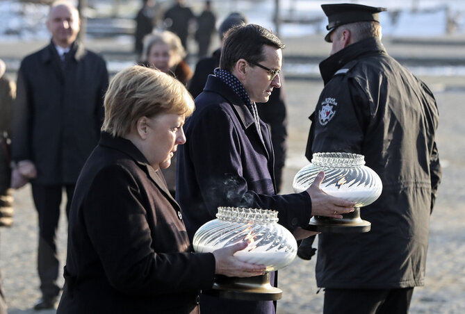 Angela Merkel és Mateusz Morawiecki mécsest helyez el az auschwitzi emlékhelyen (Fotó: AP via Beta)