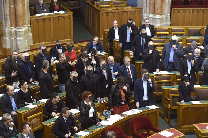 A DK, az MSZP és a Párbeszéd képviselői szavazáskor felálltak és fekete maszkot tartottak az arcuk elé (Fotó: MTI) A DK, az MSZP és a Párbeszéd képviselői szavazáskor felálltak és fekete maszkot tartottak az arcuk elé (Fotó: MTI)