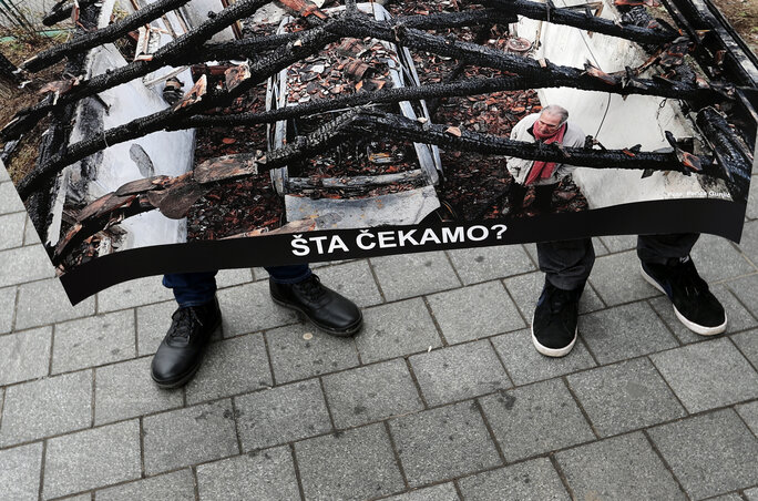 A NUNS-tüntetésen Milan Jovanović felgyújtott házának plakátra másolt fotóját hordozták(AP via Beta felvétele)