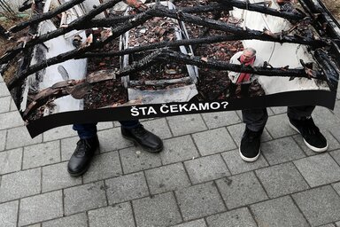 A NUNS-tüntetésen Milan Jovanović felgyújtott házának plakátra másolt fotóját hordozták(AP via Beta felvétele)