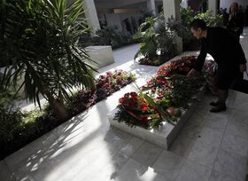 A woman lays flowers on the grave of Jovanka Broz, the late widow of former Yugoslav communist leader Josip Broz Tito, following her funeral in Belgrade, Serbia, Saturday, Oct. 26, 2013. Former Yugoslavia's first lady Jovanka Broz was laid to rest Saturda