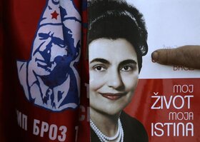 A visitor shows a book of the Jovanka Broz, widow of the former Yugoslav communist leader Josip Broz Tito, with its title reading: "My life, My Truth," right, and an illustration of Tito, before the funeral in Belgrade, Serbia, Saturday, Oct. 26, 2013. Jo